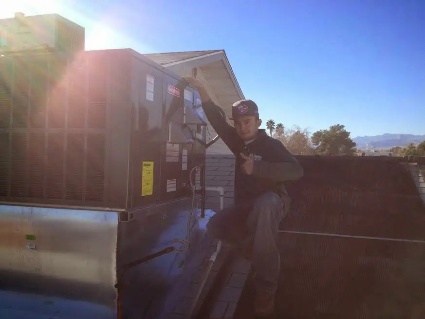 HVAC technician performing Boiler Repair on a rooftop unit in Lady Lake